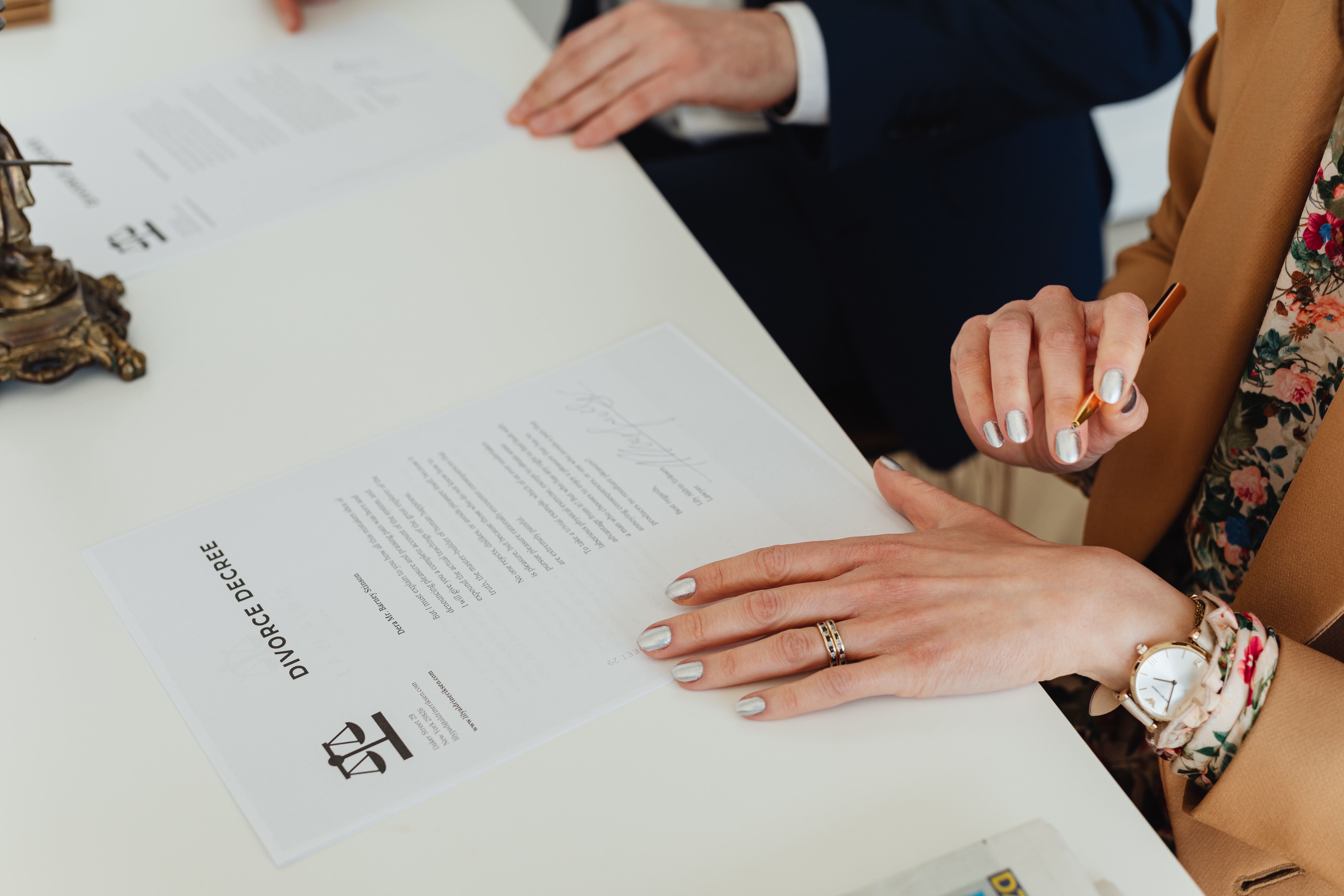 dos personas firmando documentos